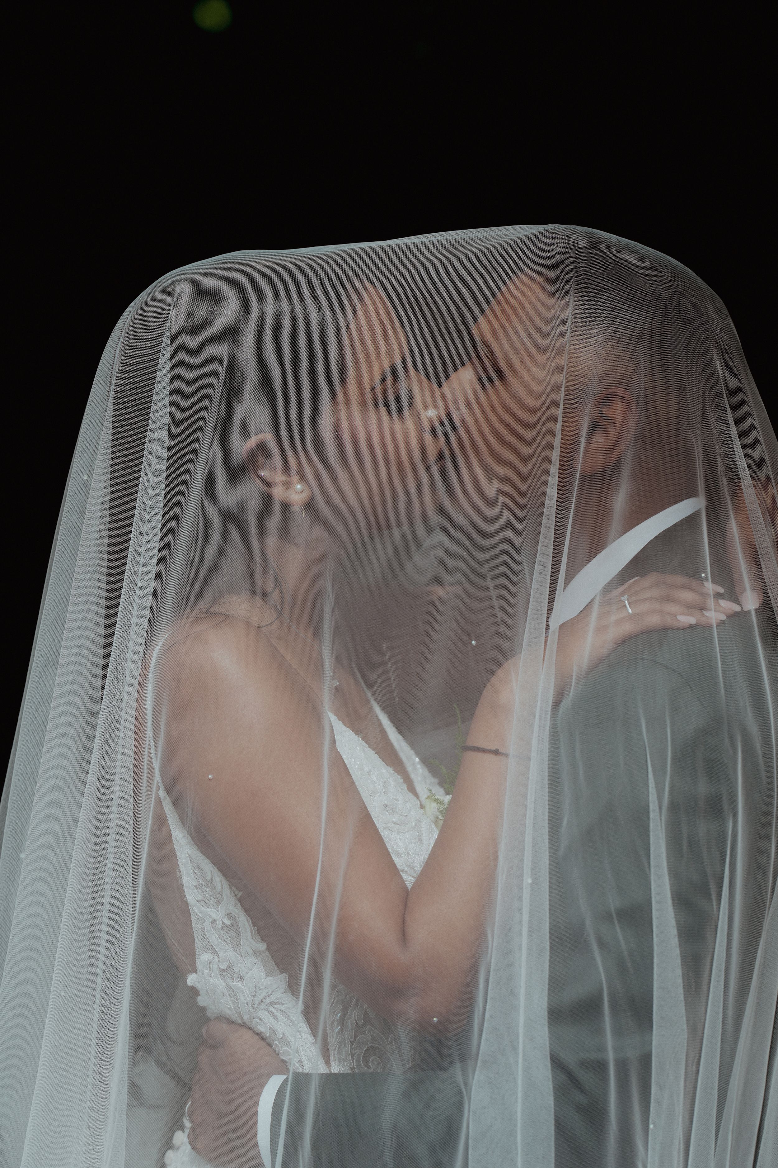 Intiem bruidsportret onder een doorschijnende sluier, gefotografeerd door Shaanthi Photography