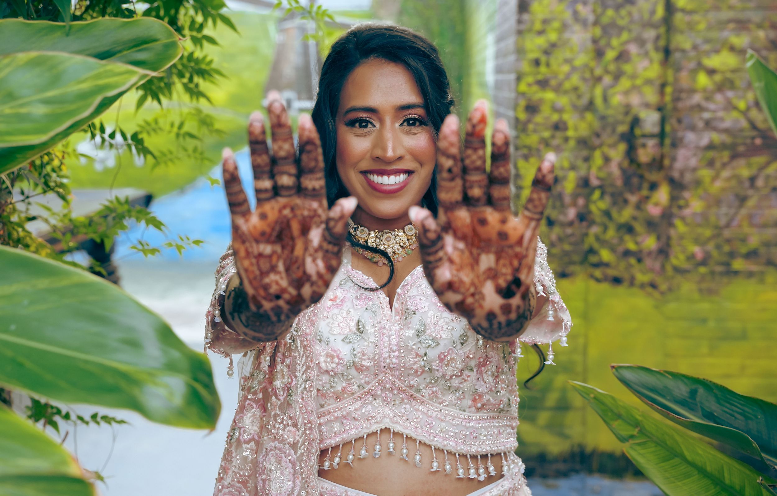 Hindoestaanse bruid in een roze lehenga toont haar mehndi