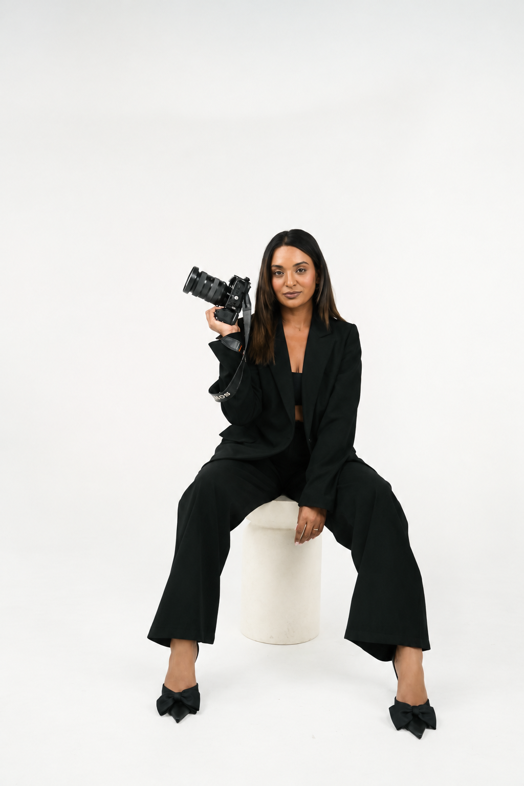 Shaanthi Ramsaran in een zwart pak met haar Sony-camera